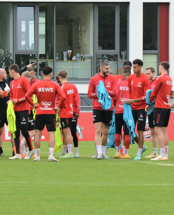 Die Spieler des 1. FC Köln ziehen sich Leibchen über.