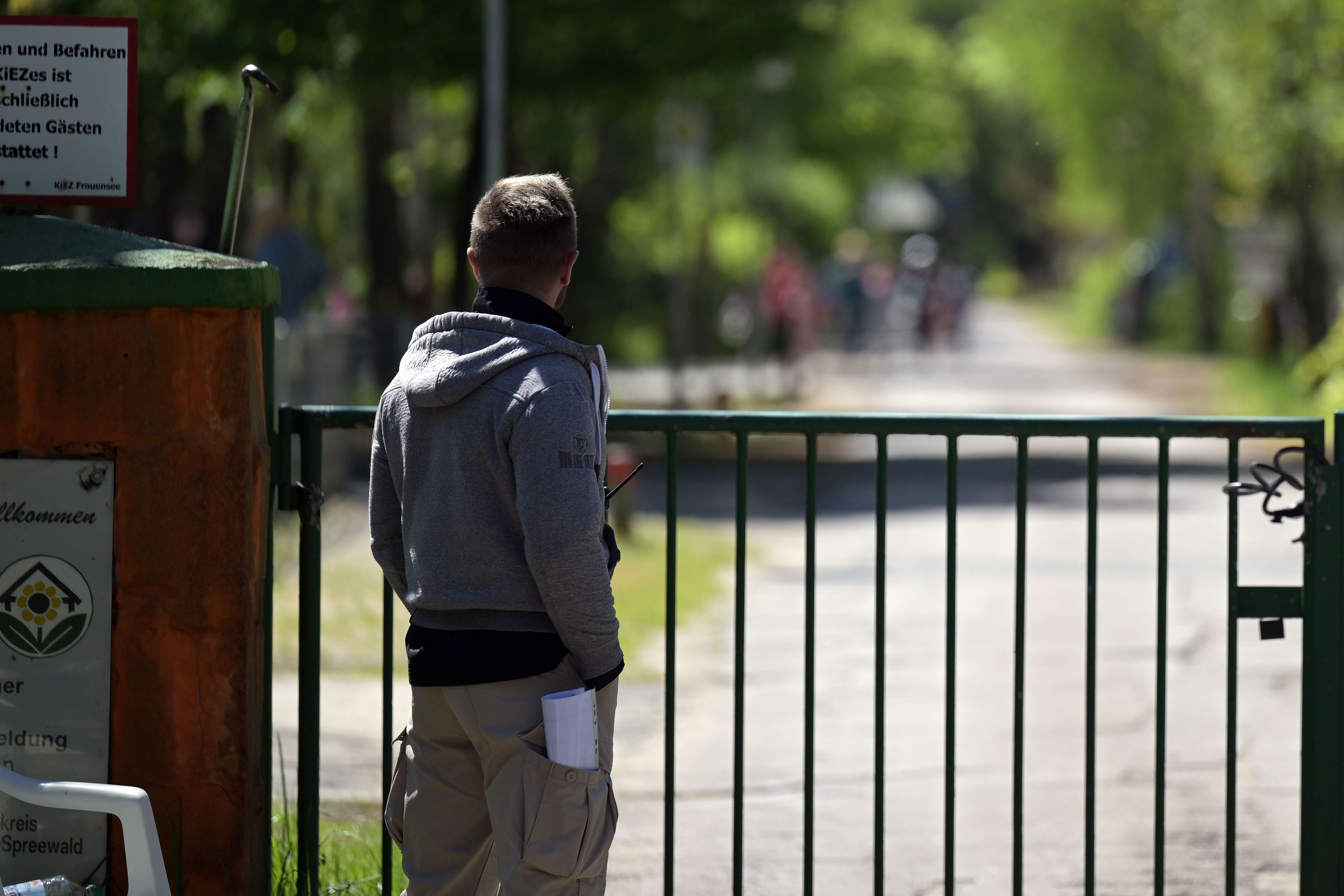 Ein Mann schaut über den Zaun eines Ferienlagers in Heidesee. Nach der rassistischen Beleidigungen von Berliner Schülerinnen und Schüler während eines Aufenthalts in einer Ferienanlage in Südbrandenburg hat sich die Einrichtung bestürzt über den Vorfall gezeigt.
