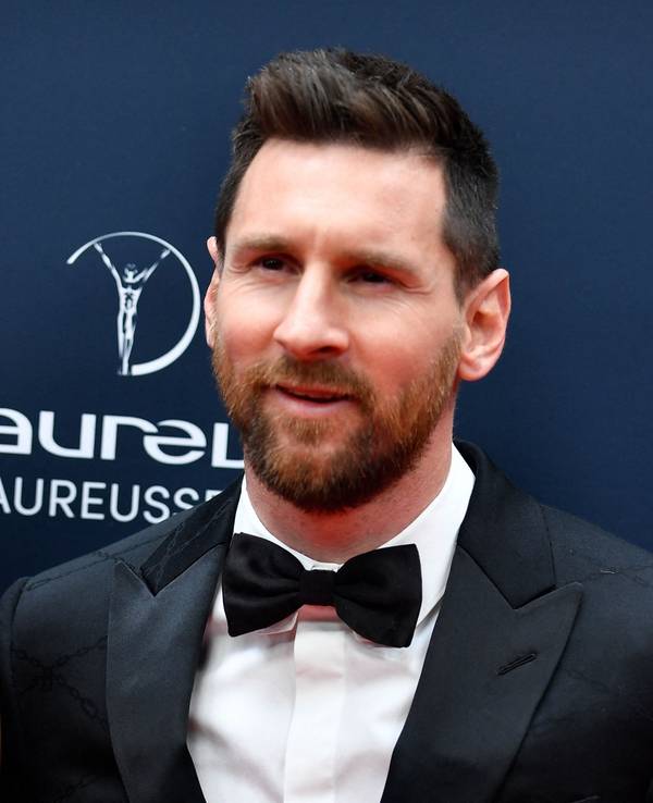 Lionel Messi steht mit seiner Frau Antonela Roccuzzo auf dem roten Teppich in Paris und posiert für die Kameras.
