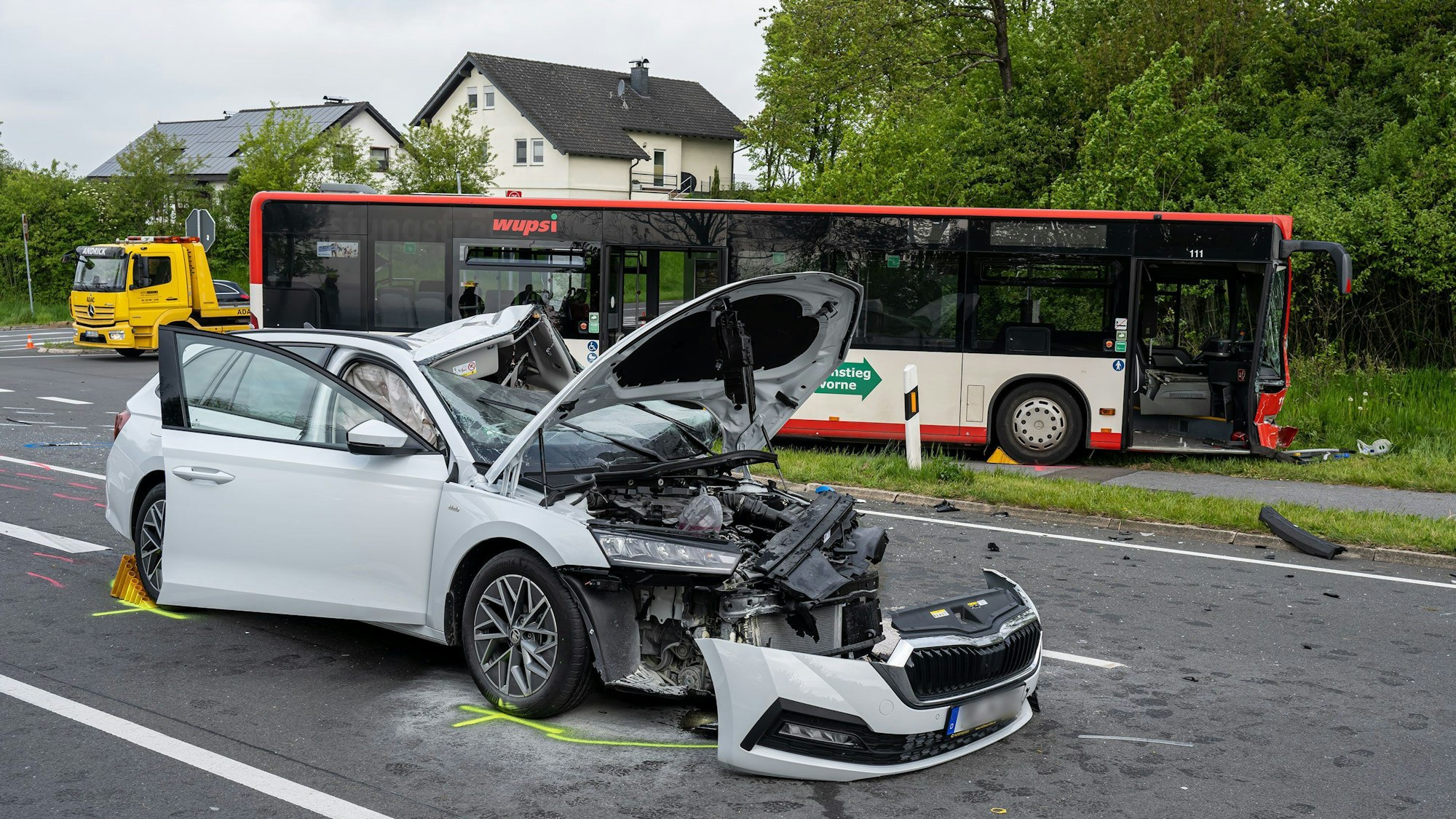 Ein schwer beschädigtes Auto und ein Bus stehen an einer Unfallstelle im Oberbergischen Kreis. In Wipperfürth sind beim Zusammenstoß beider Fahrzeuge die beiden Fahrer schwer verletzt worden. Fahrgäste saßen bei der Kollision am Dienstagmorgen nicht im Bus.