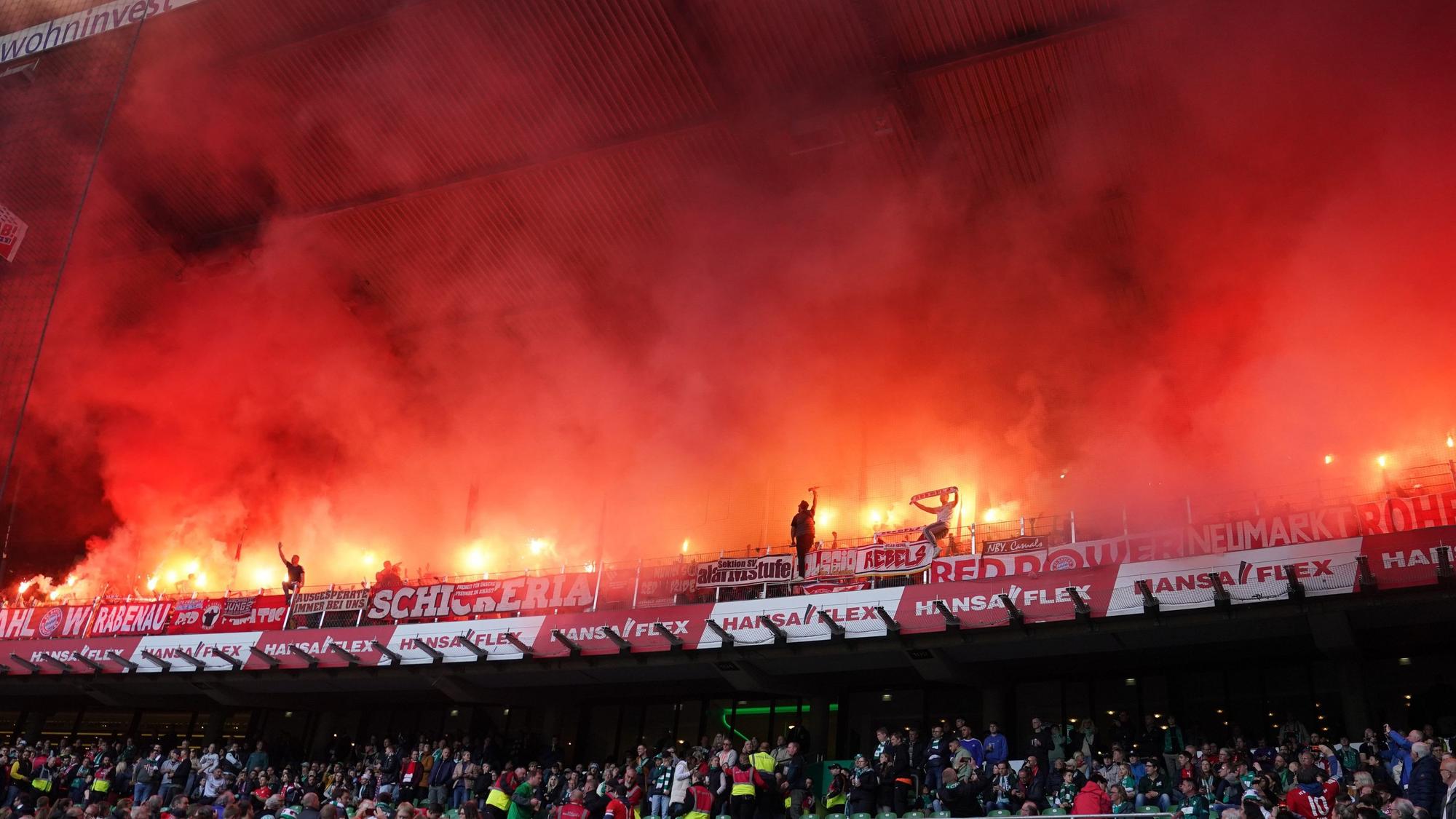 Bayern-Fans brennen auf der Tribüne Feuerwerkskörper ab.