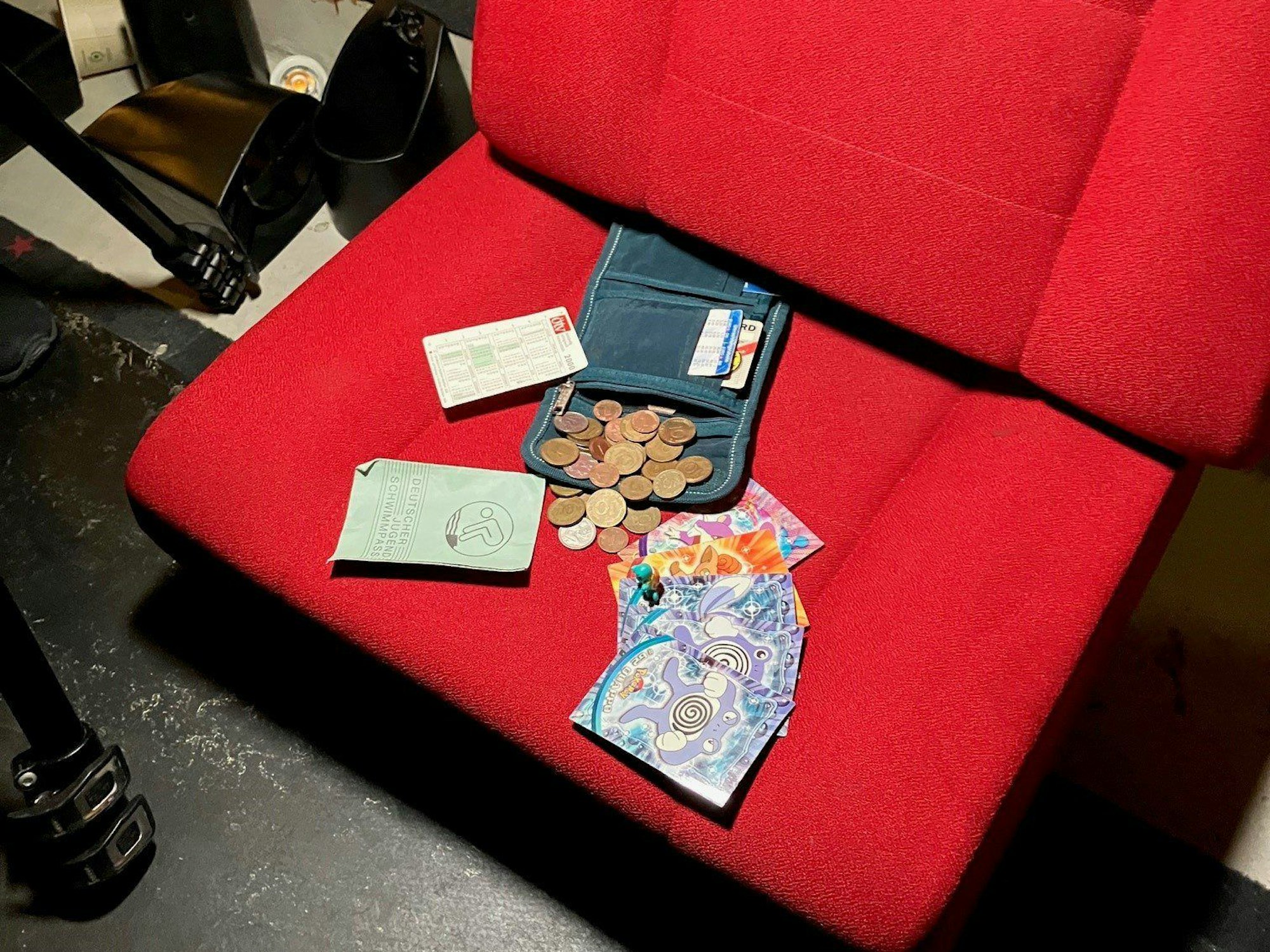 Ein Portemonnaie, das nach 23 Jahren zwischen Kinosesseln gefunden wurde, liegt samt Inhalt auf einem roten Sessel im Cineplex in Hamm.