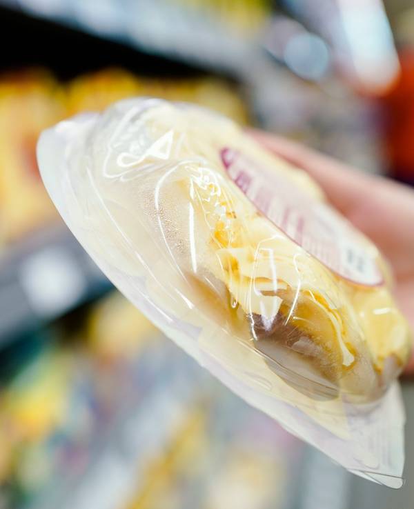 Stefan Fitzer, Lebensmittelkontrolleur beim Landratsamt Rhein-Neckar-Kreis in der Abteilung Veterinäramt und Verbraucherschutz, hält in einem Supermarkt bei einer Kontrolle eine Packung Käse in der Hand.