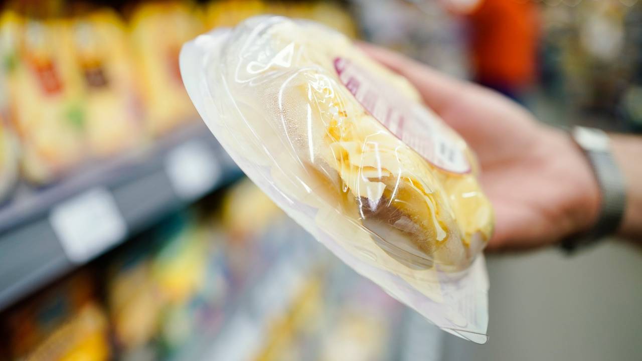 Stefan Fitzer, Lebensmittelkontrolleur beim Landratsamt Rhein-Neckar-Kreis in der Abteilung Veterinäramt und Verbraucherschutz, hält in einem Supermarkt bei einer Kontrolle eine Packung Käse in der Hand.