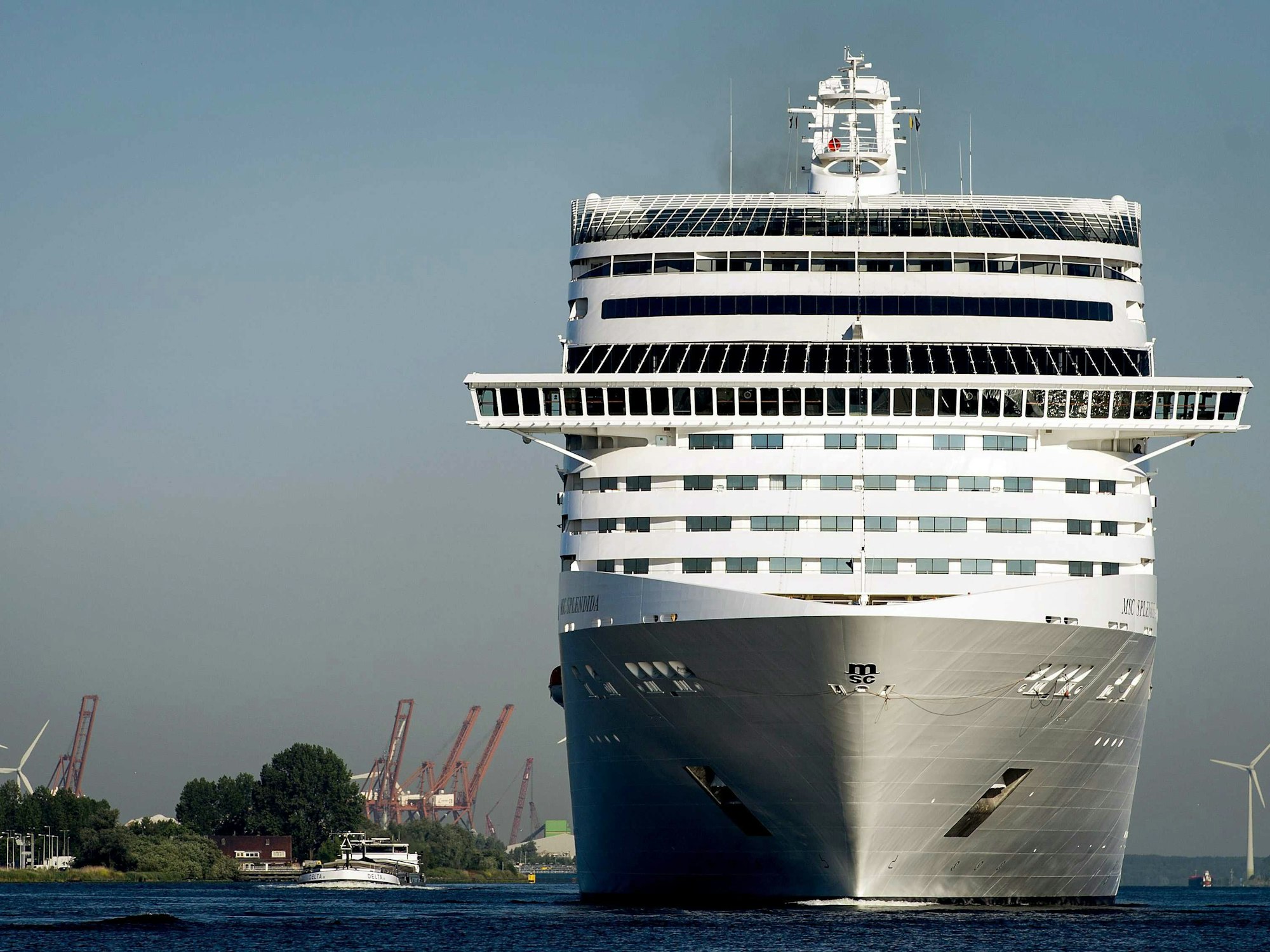 Die MSC Splendida der Kreuzfahrtgesellschaft MSC (Mediterranean Shipping Company) Cruises überragt andere Schiffe bei ihrer Ankunft im Passagierterminal Amsterdam, hier im Juli 2015.