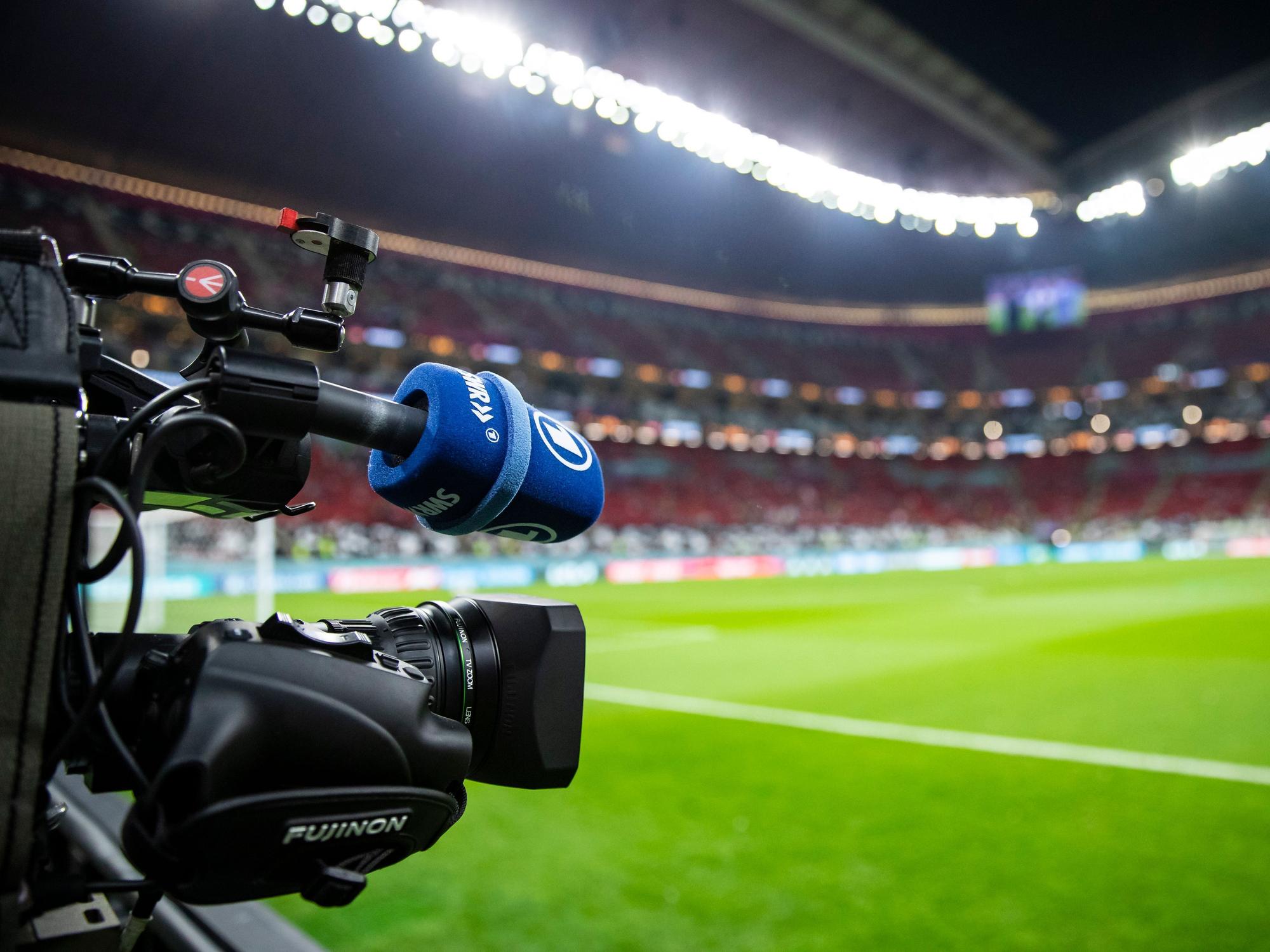 Eine TV-Kamera der ARD steht am Spielfeldrand vor dem Spiel.