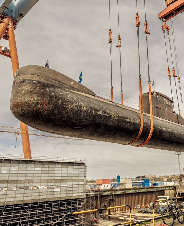 Ein U-Boot wird an einem Hafen ins Trockendock transportiert.