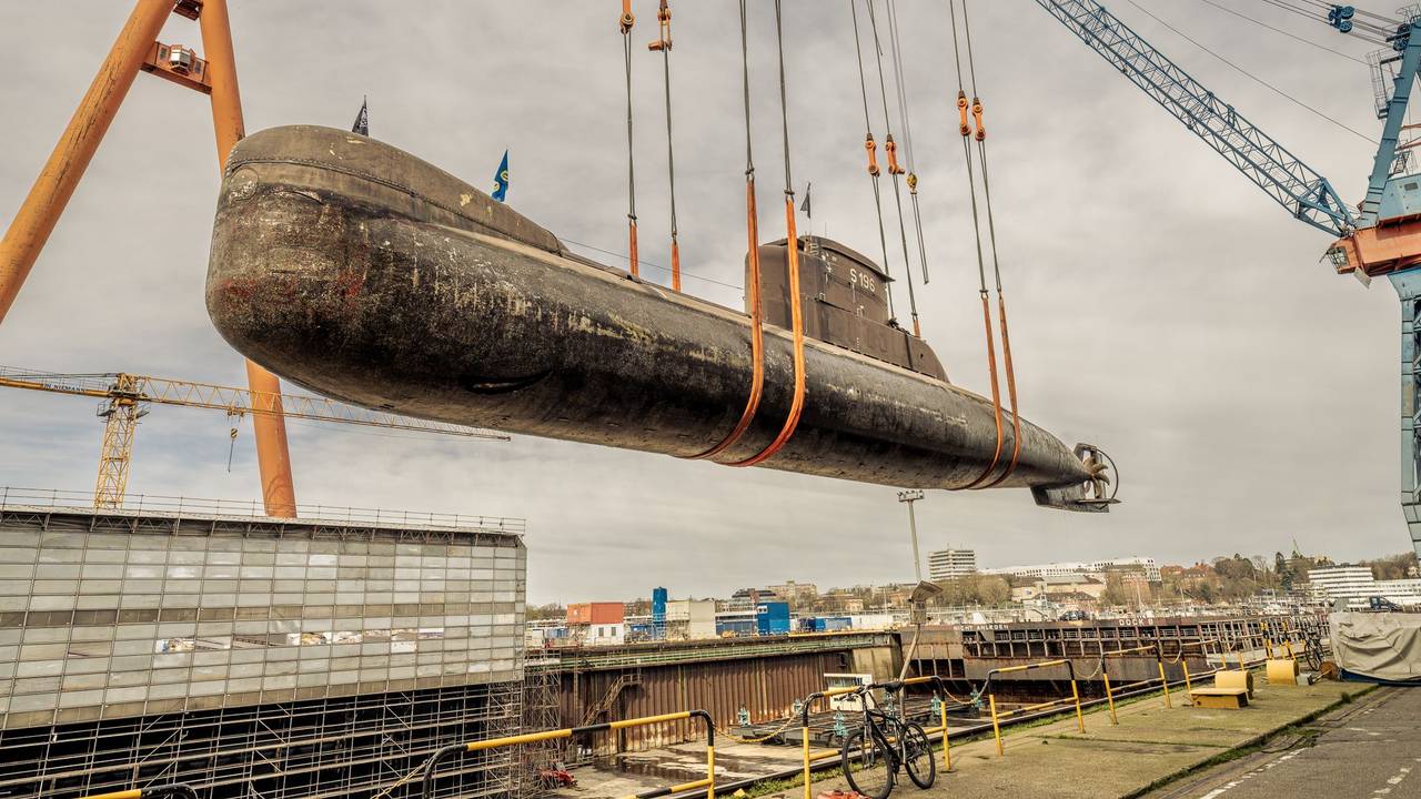 Ein U-Boot wird an einem Hafen ins Trockendock transportiert.