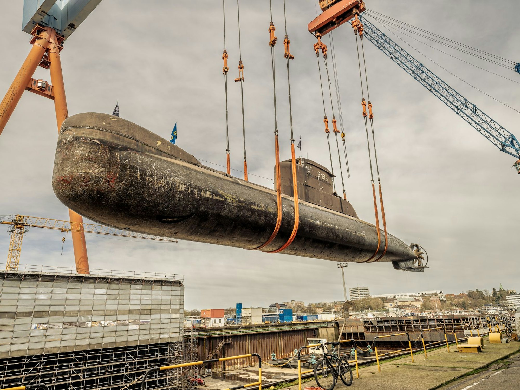 Ein U-Boot wird an einem Hafen ins Trockendock transportiert.