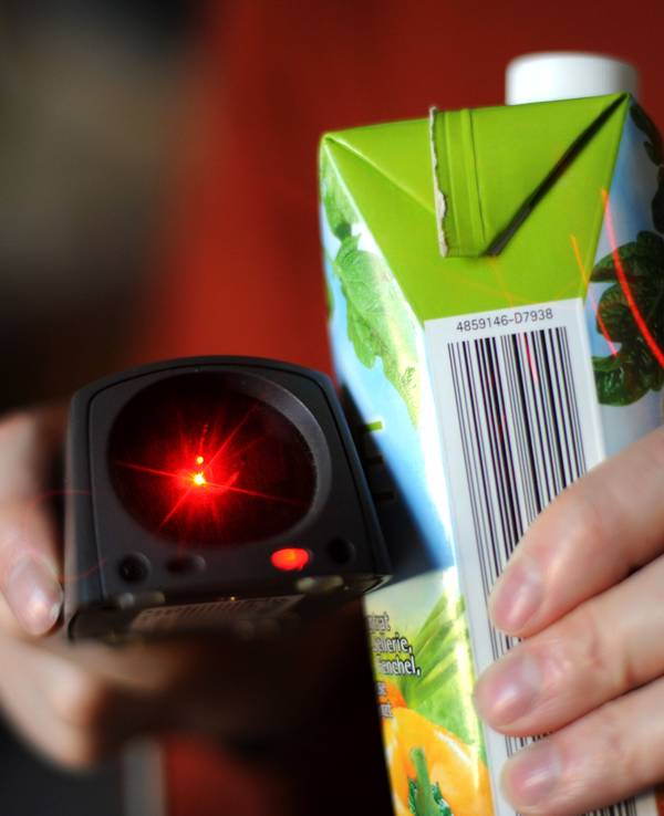 Ein Barcode-Scanner, hier im März 2011 in Kassel, wird vor ein Produkt gehalten, auf dem ein Strichcode abgebildet ist.
