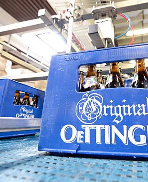 Eine Kiste Oettinger-Bier steht in der Oettinger Brauerei auf einem Transportband.