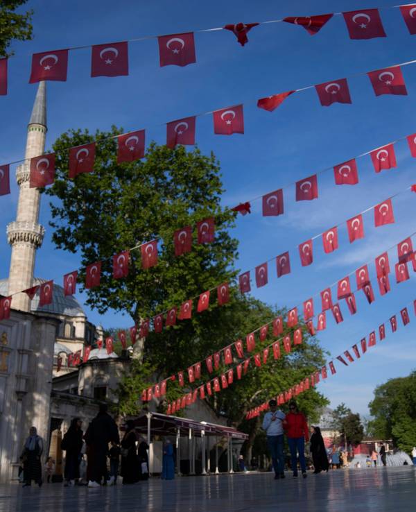 Ein Junge spielt unter türkischen Fahnen, die neben der Eyub-Sultan-Moschee in Istanbul dekoriert sind.