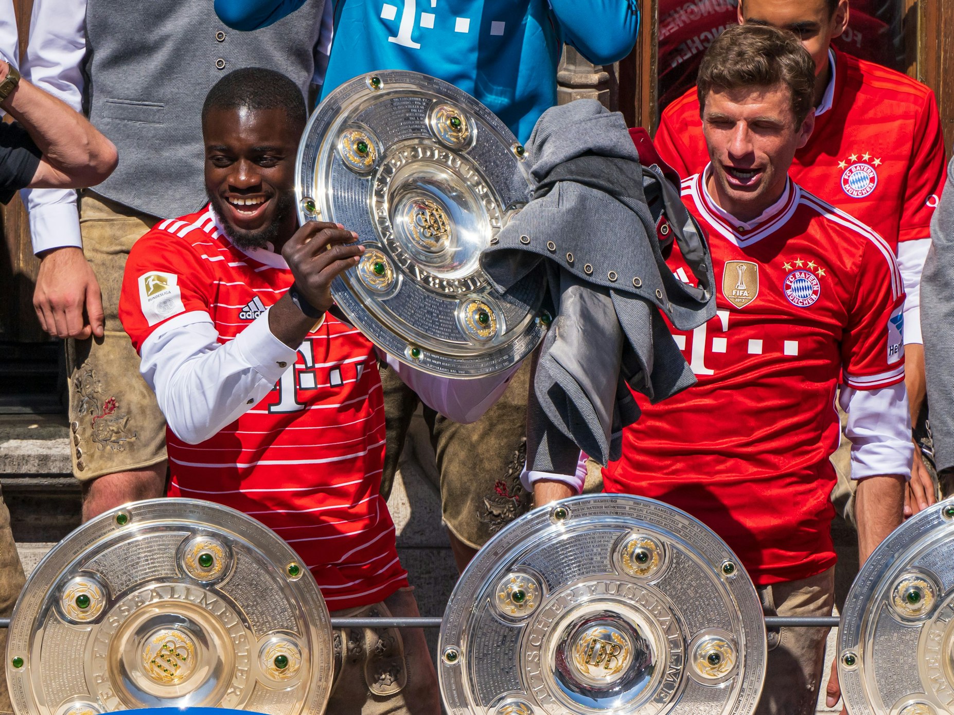 Die Spieler Dayot Upamecano (l) und Thomas Müller vom FC Bayern München jubeln auf dem Rathausbalkon über die deutsche Fußball-Meisterschaft.