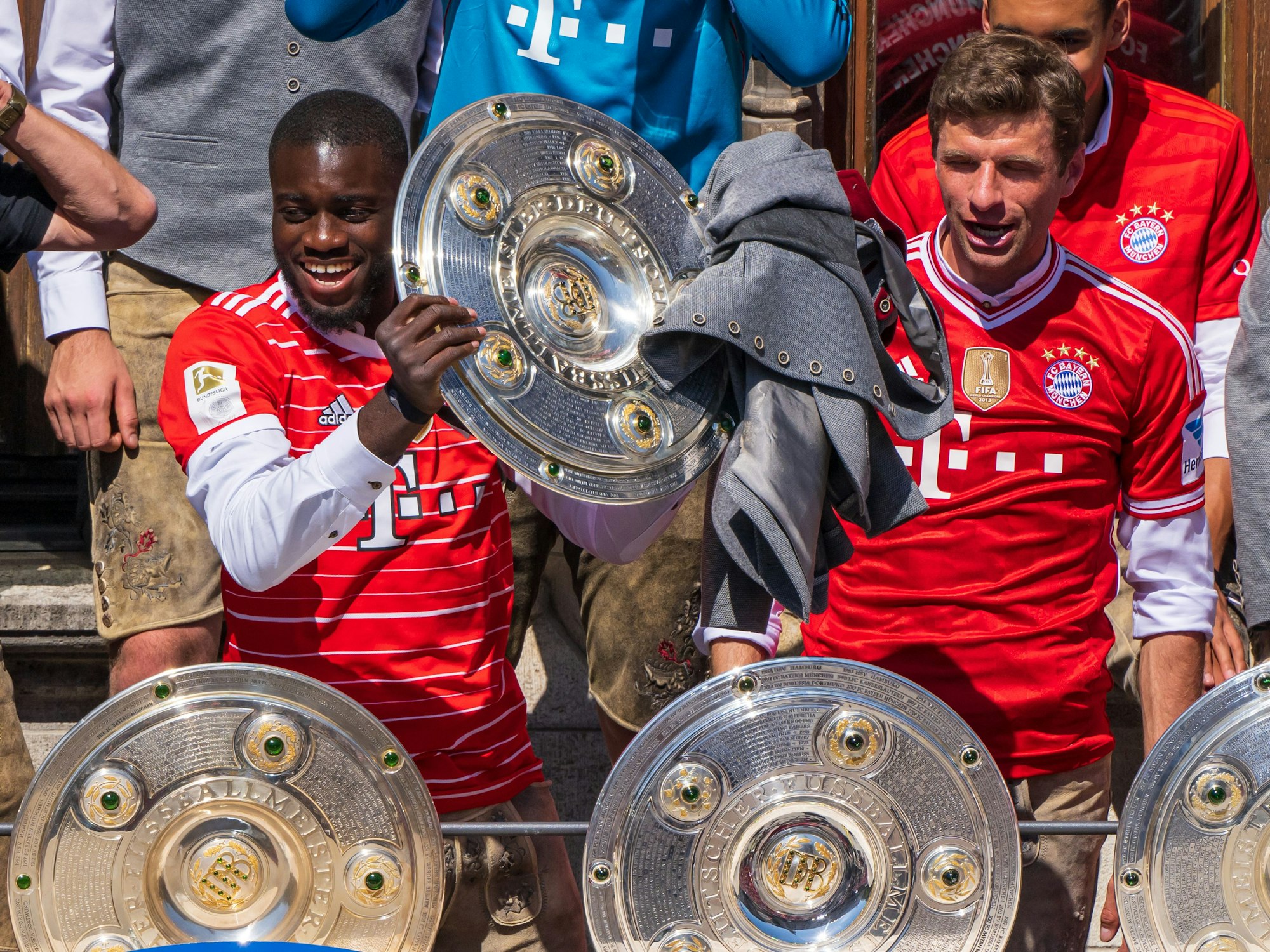 Die Spieler Dayot Upamecano (l) und Thomas Müller vom FC Bayern München jubeln auf dem Rathausbalkon über die deutsche Fußball-Meisterschaft.