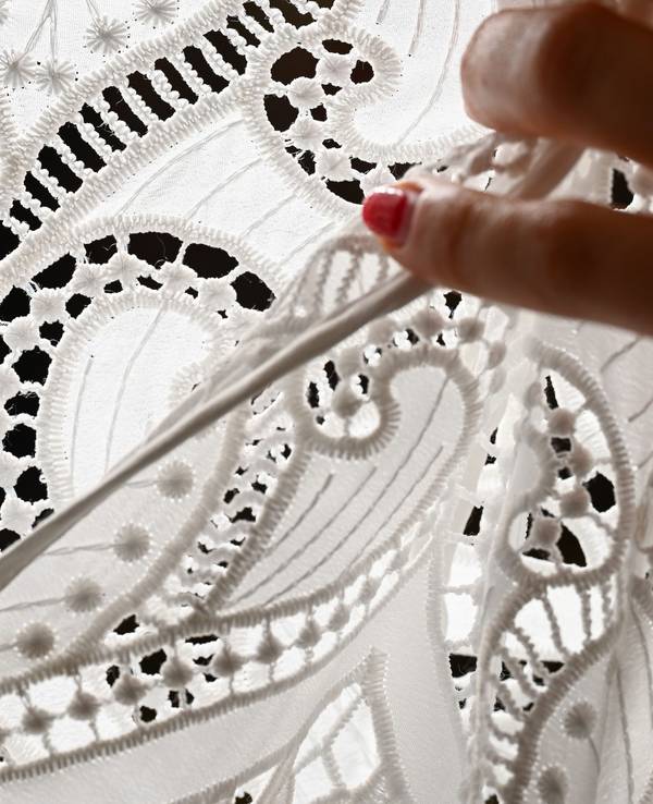 Ornamente aus Spitze sind an einem Dirndl angebracht