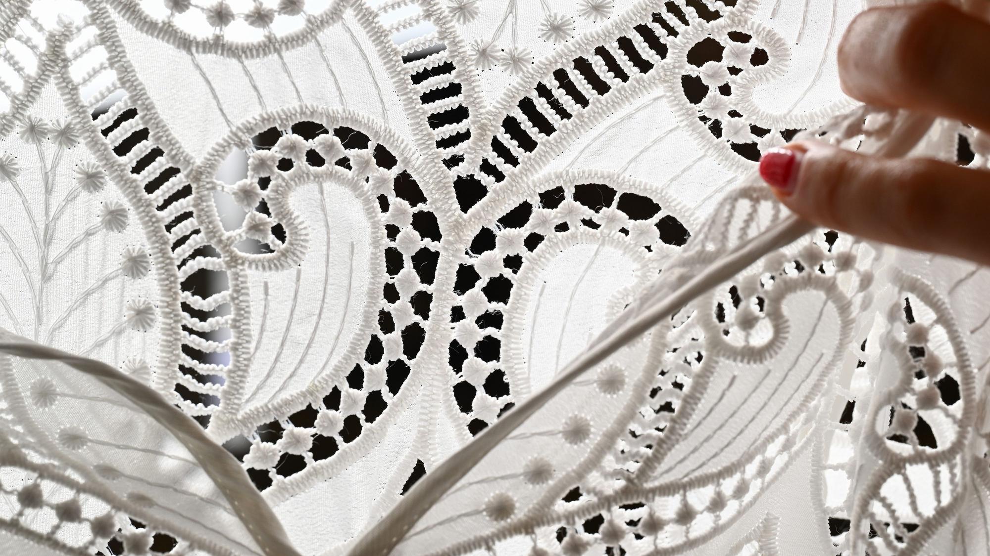 Ornamente aus Spitze sind an einem Dirndl angebracht