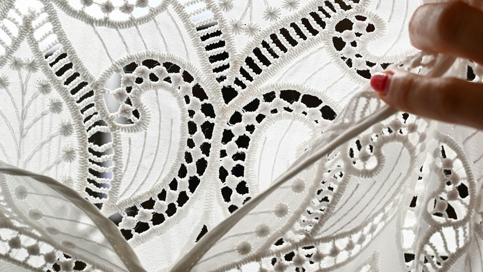 Ornamente aus Spitze sind an einem Dirndl angebracht