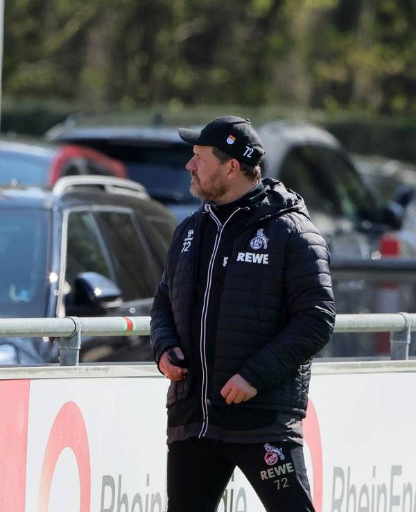 Christian Keller und Steffen Baumgart unterhalten sich beim Training des 1. FC Köln an der Bande.