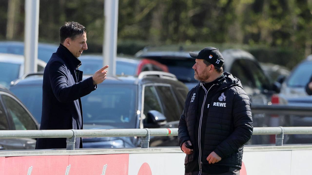 Christian Keller und Steffen Baumgart unterhalten sich beim Training des 1. FC Köln an der Bande.