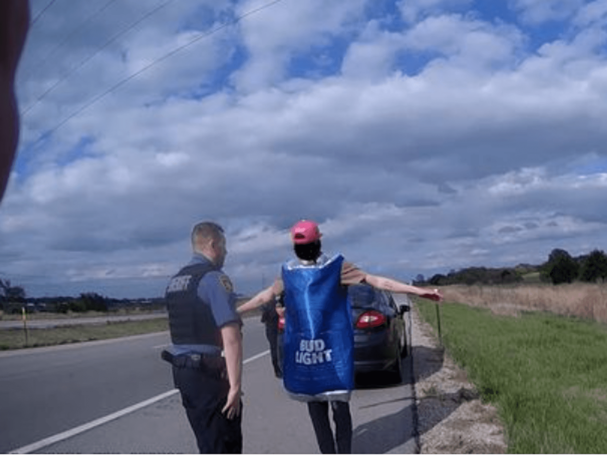 Ein amerikanischer Polizist überprüft Verdächtigen in Bud Light Bier-Kostüm.