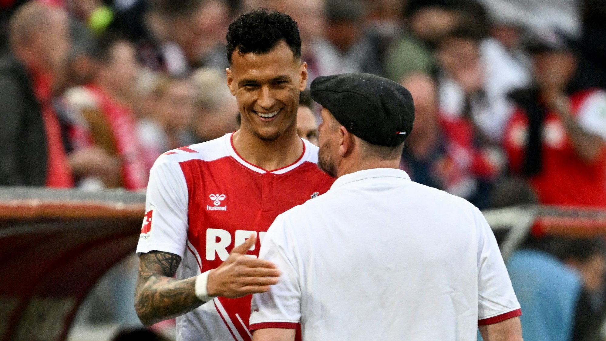 Davie Selke lächelt Steffen Baumgart an.