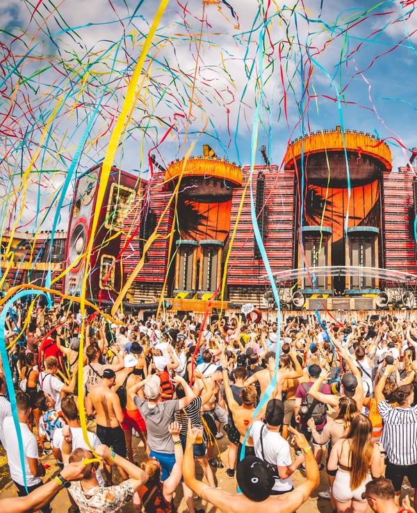 Menschen stehen im Juli 2022 vor der Parookaville-Mainstage. Bunte Luftschlangen fliegen durch die Luft.