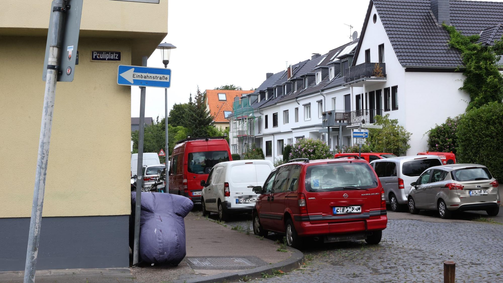 Zahlreiche Autos stehen am Pauliplatz in Köln an der Straße.