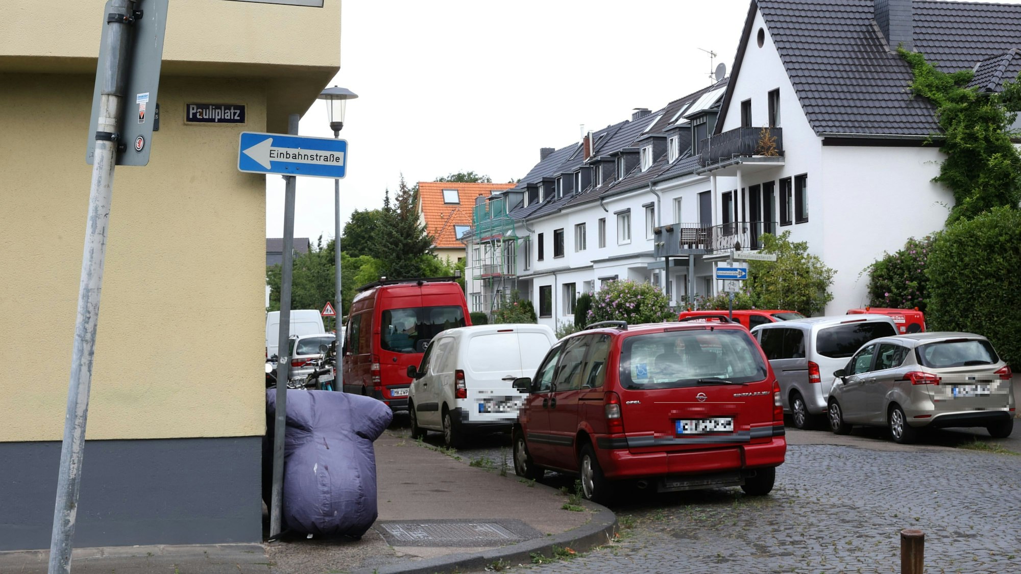Zahlreiche Autos stehen am Pauliplatz in Köln an der Straße.