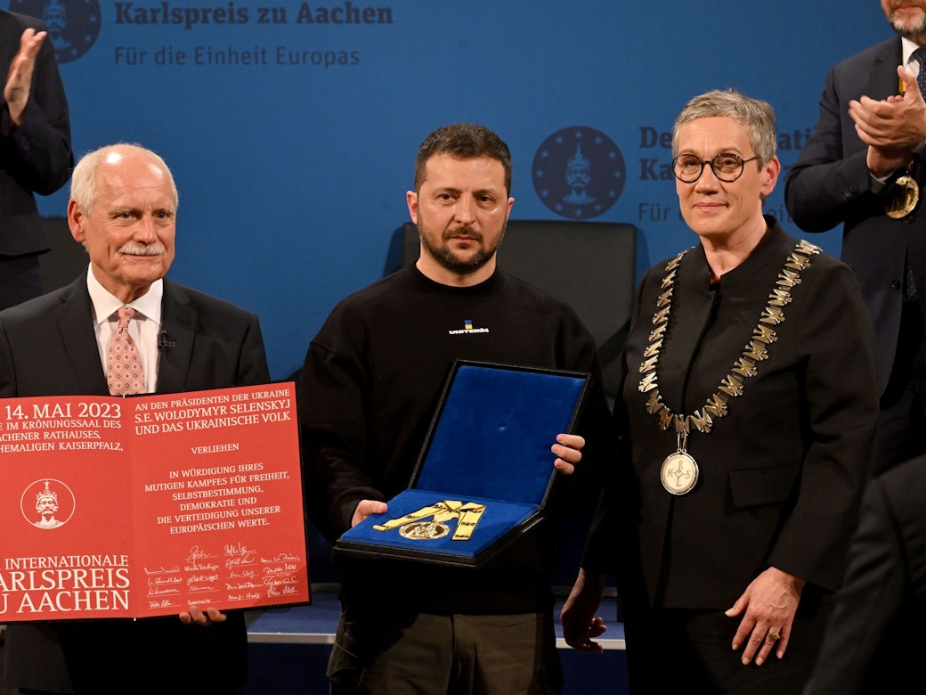 Wolodymyr Selenskyj (M) erhält am Sonntag (14. Mai 2023) den Karlspreis für Verdienste um die Einheit Europas von Sibylle Keupen (parteilos, r), Oberbürgermeisterin von Aachen, und Jürgen Linden (l), Vorsitzender der Gesellschaft zur Verleihung des Internationalen Karlspreises zu Aachen, im Krönungssaal des Rathauses.