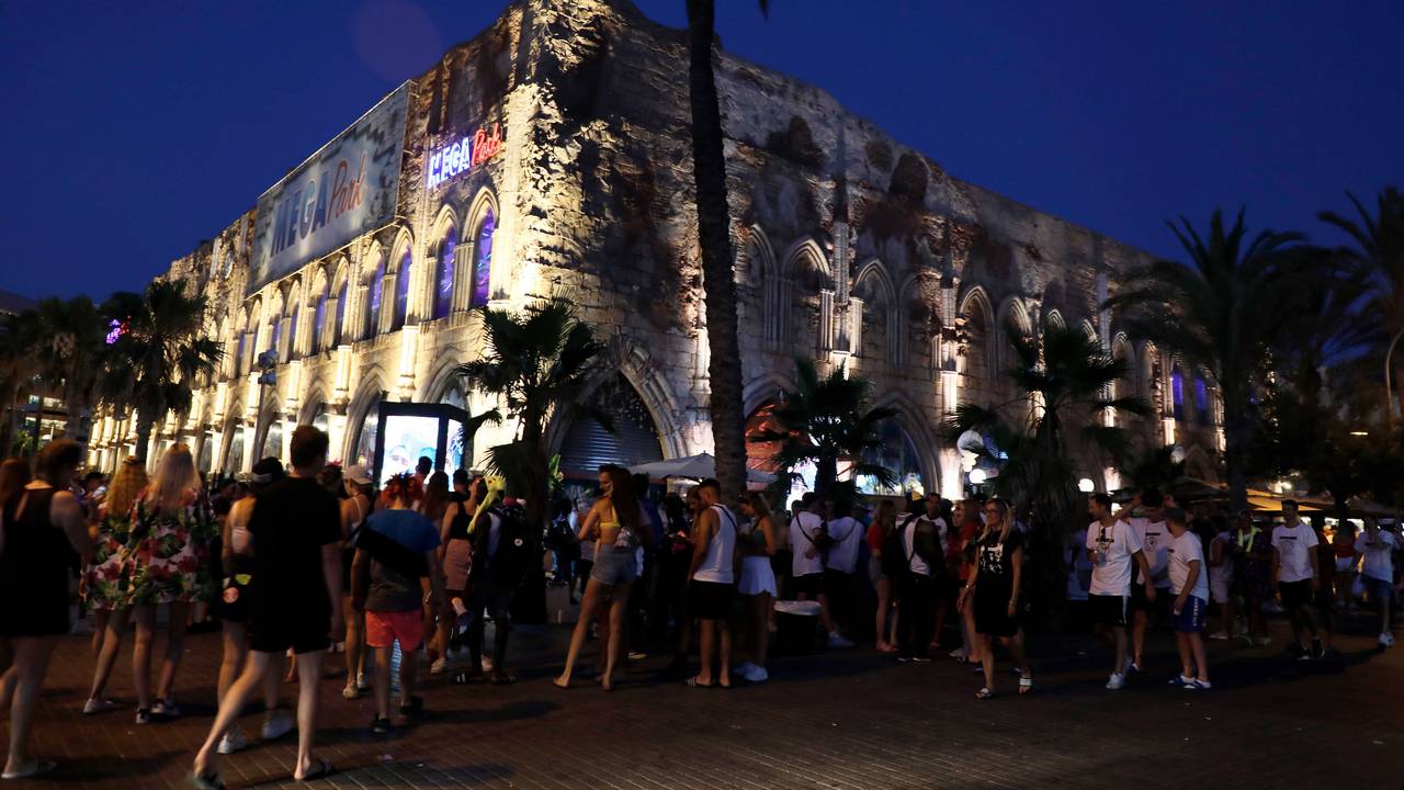 Menschen gehen neben dem Megapark am Strand von Arenal auf Mallorca vorbei.