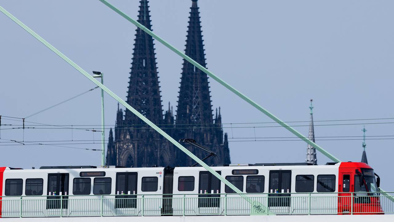 Eine Straßenbahn der Kölner Verkehrsbetriebe fährt über die Severinsbrücke vor der Kulisse des Kölner Doms.