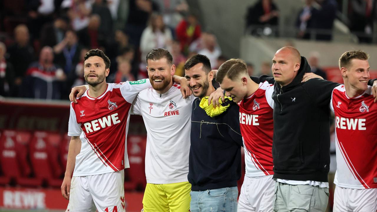 Die Profis des 1. FC Köln stehen Arm in Arm vor der Südkurve.