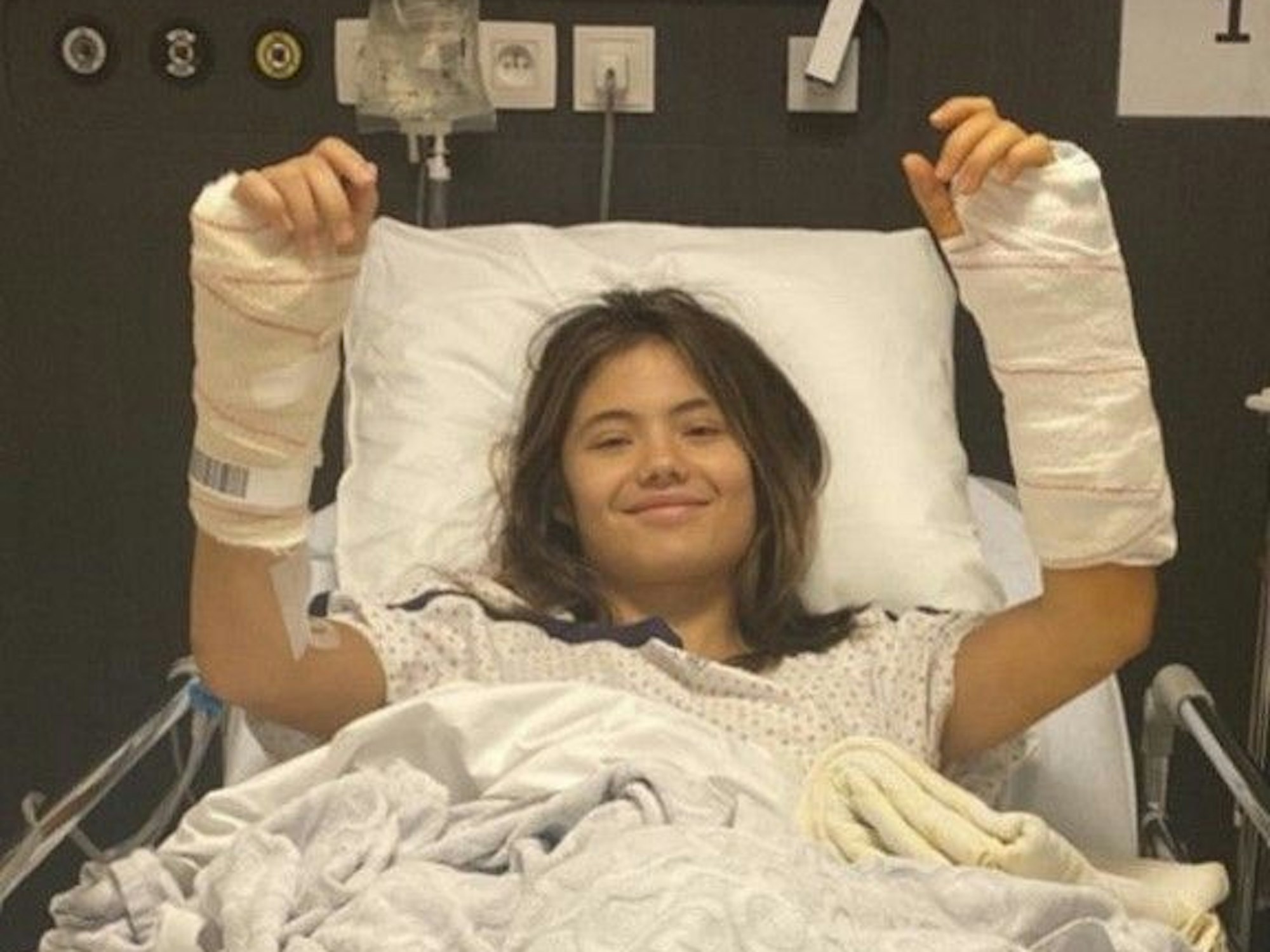 Emma Raducanu liegt in einem Krankenhaus-Bett. Beide Unterarme sind eingegipst.