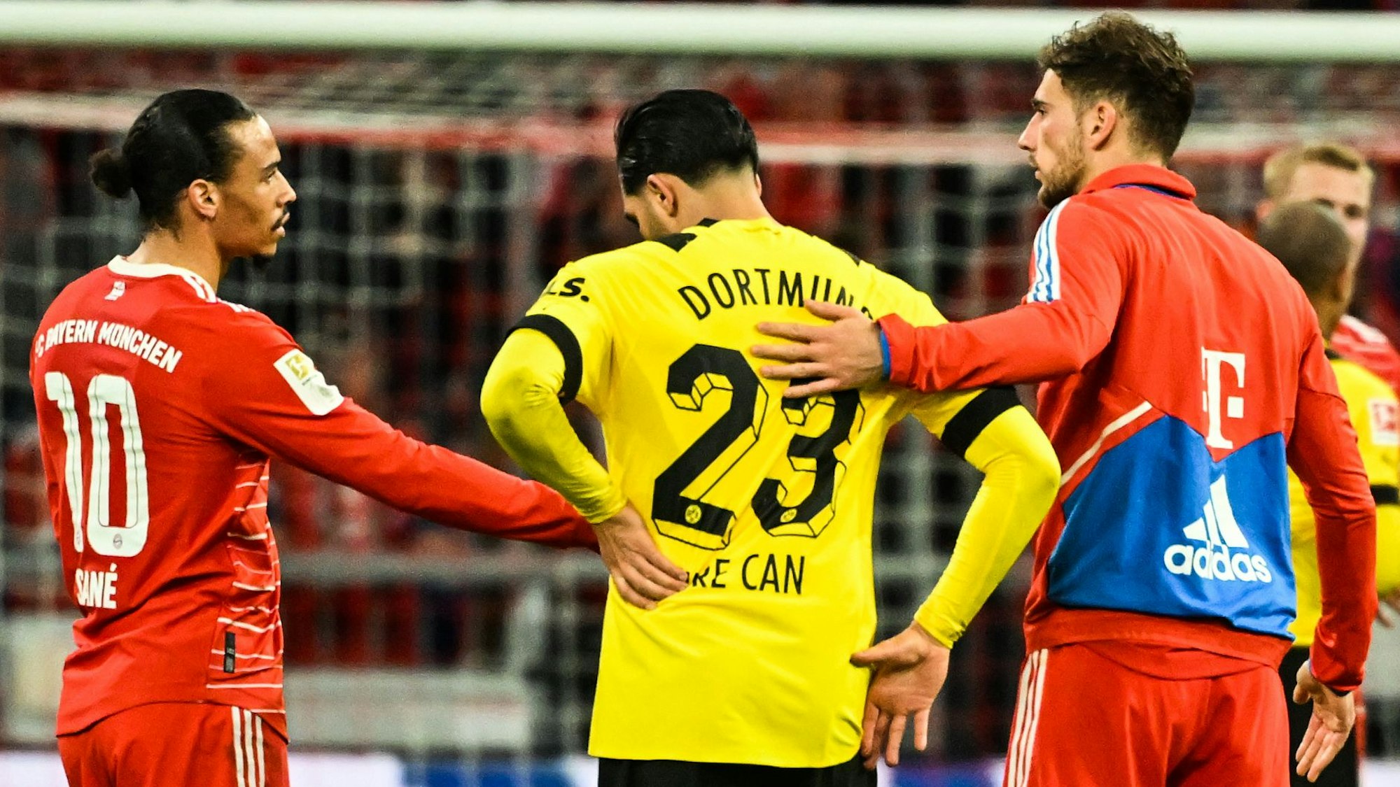 Leroy Sané und Leon Goretzka trösten Emre Can nach dem Spiel zwischen Bayern und Dortmund.