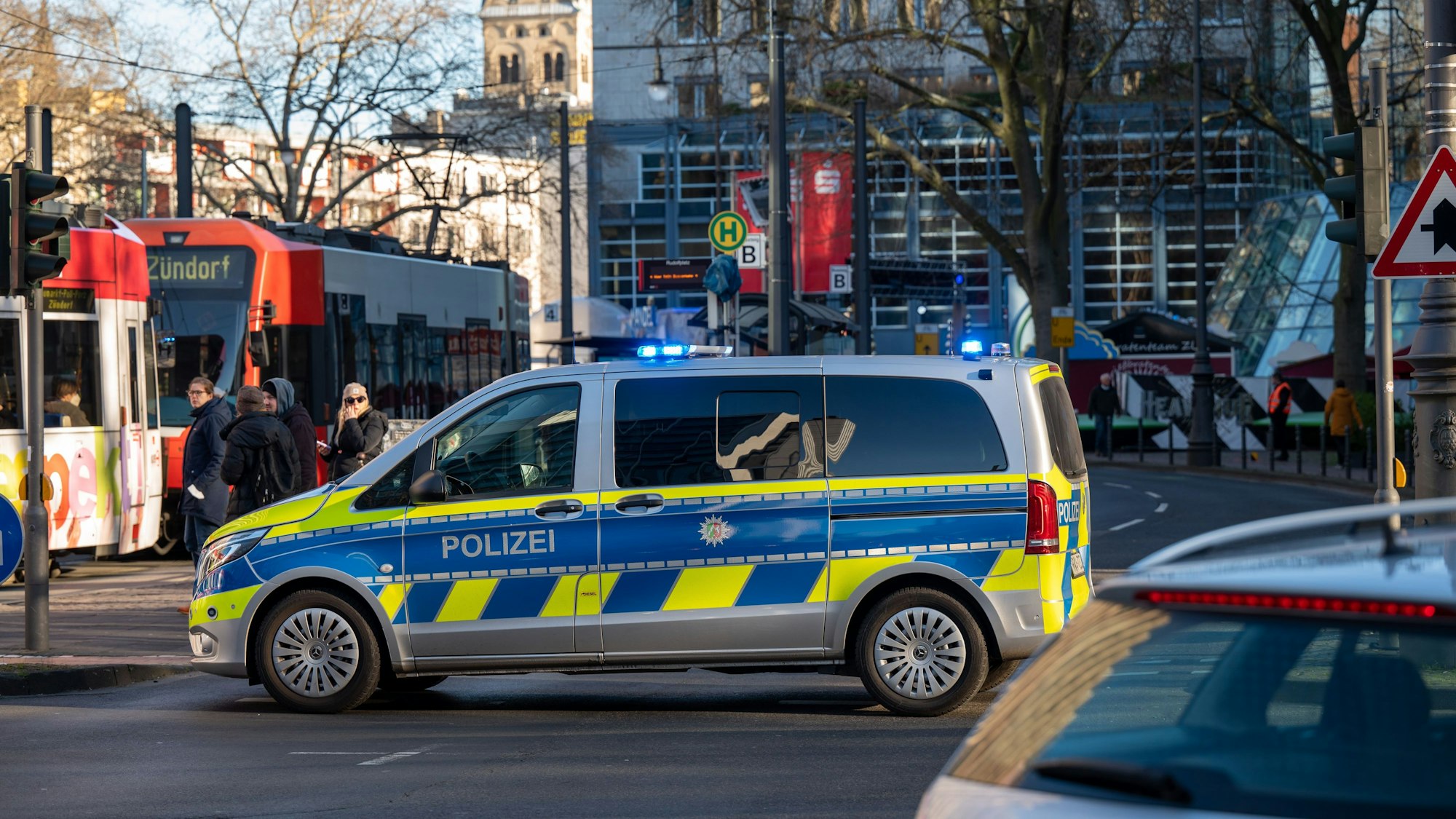 Ein Polizeifahrzeug am Rudolfplatz (Symbolfoto vom 20. Dezember 2021). Aktuell sucht die Polizei nach einem Mann, der einen 32-jährigen Kölner mehrfach getreten haben soll.