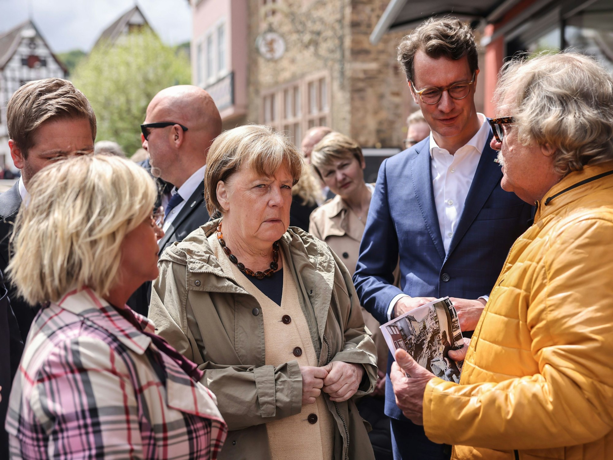 Bad Münstereifel: Die ehemalige Bundeskanzlerin Angela Merkel (M, CDU), Hendrik Wüst (2.v.r. CDU), Ministerpräsident Nordrhein-Westfalen, Bürgermeisterin Sabine Preiser-Marian (l, CDU) sprechen in Bad Münstereifel mit dem Cafehaus Besitzer Günter Portz (r).