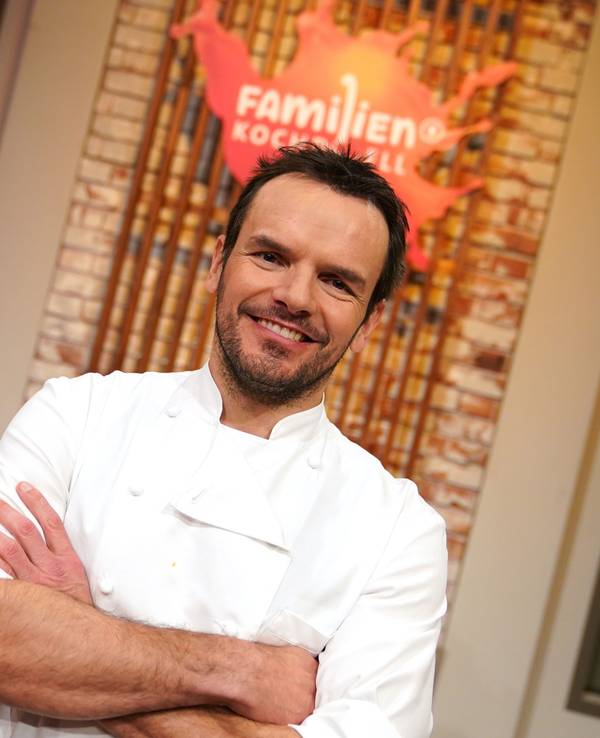 Fernsehkoch Steffen Henssler steht in der Studiokulisse der Sendung „Familien-Kochduell“.