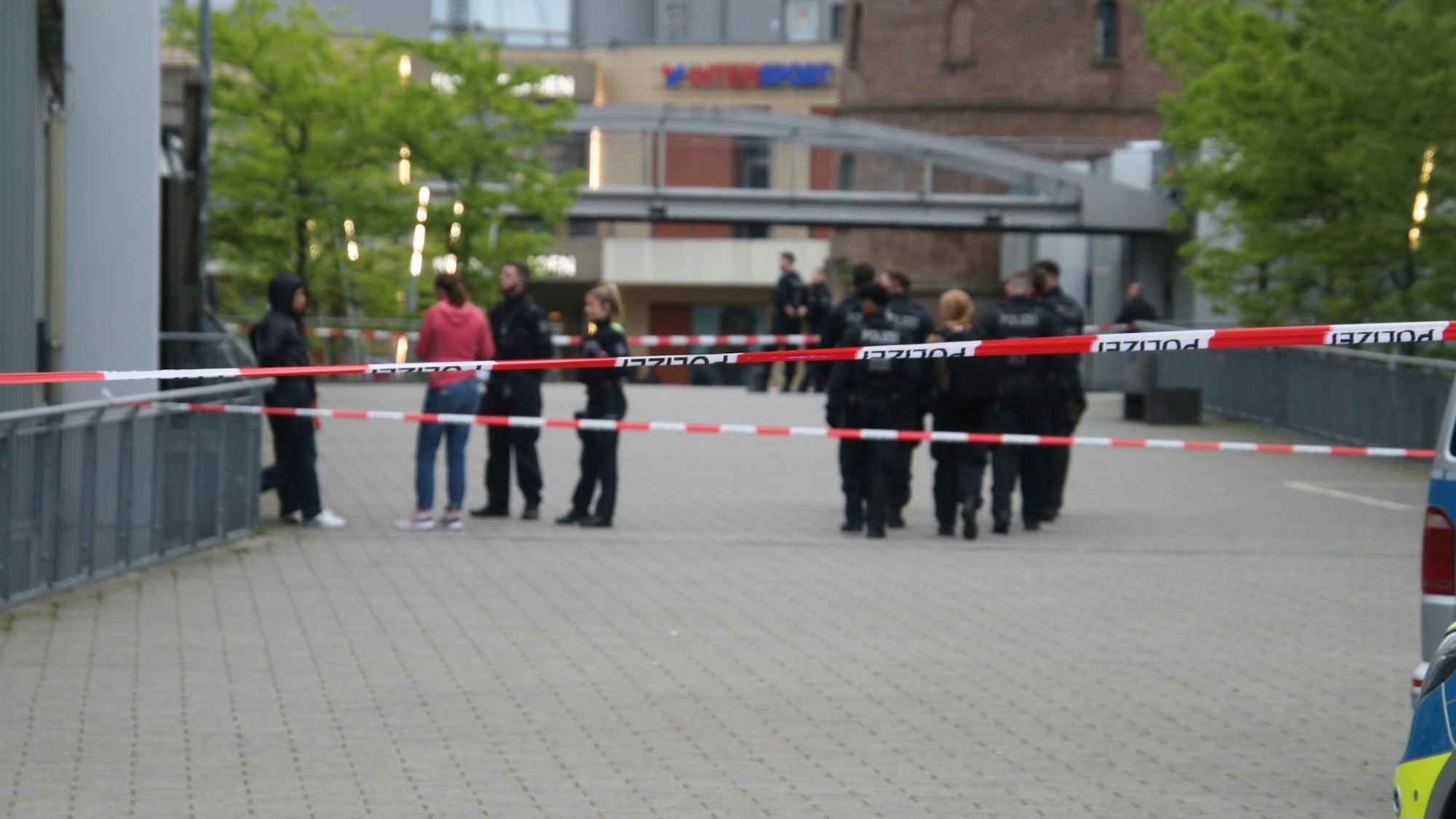 Menschen stehen vor einem Eingang der Köln-Arcaden.