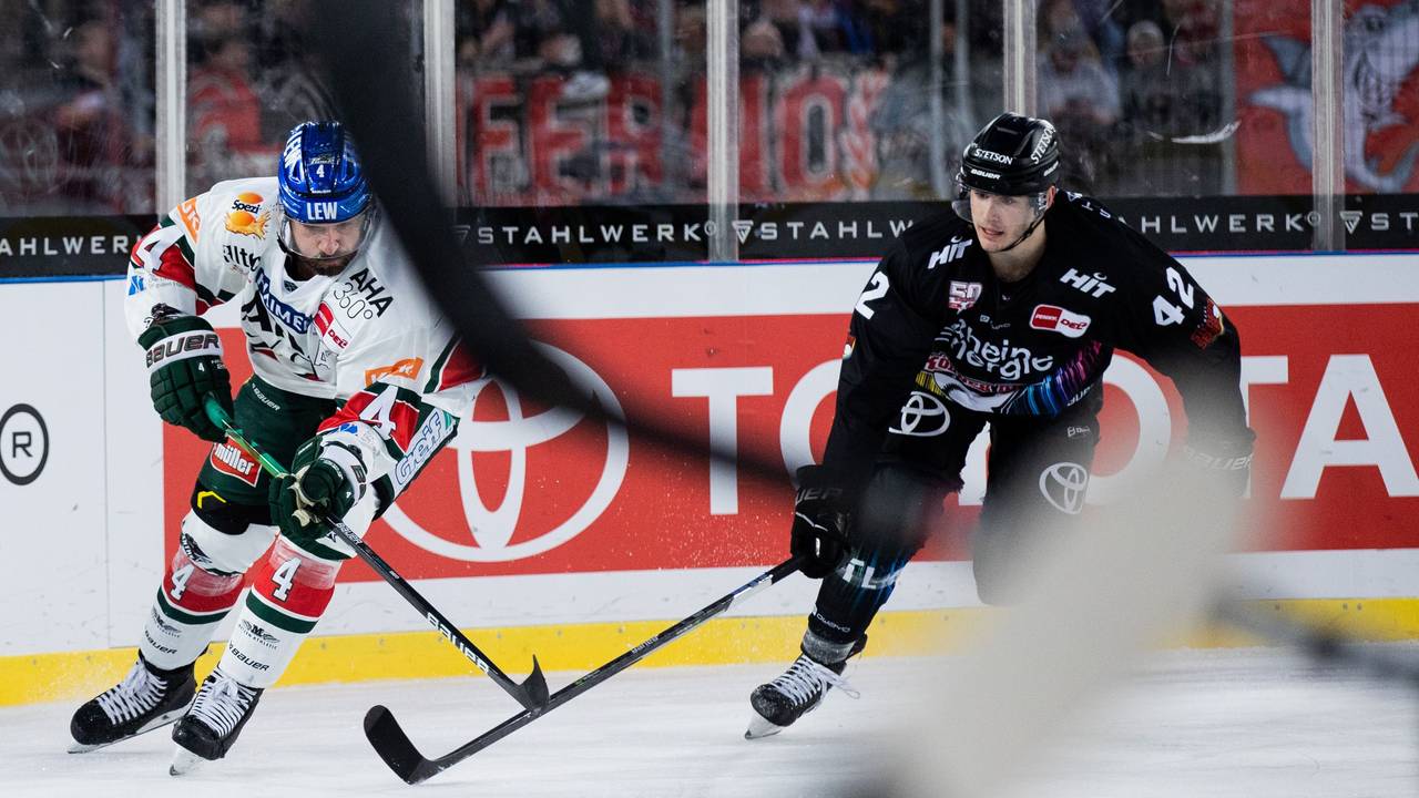 Kölns Luis Üffing (r) und Augsburgs Henry Haase versuchen, an den Puck zu kommen.