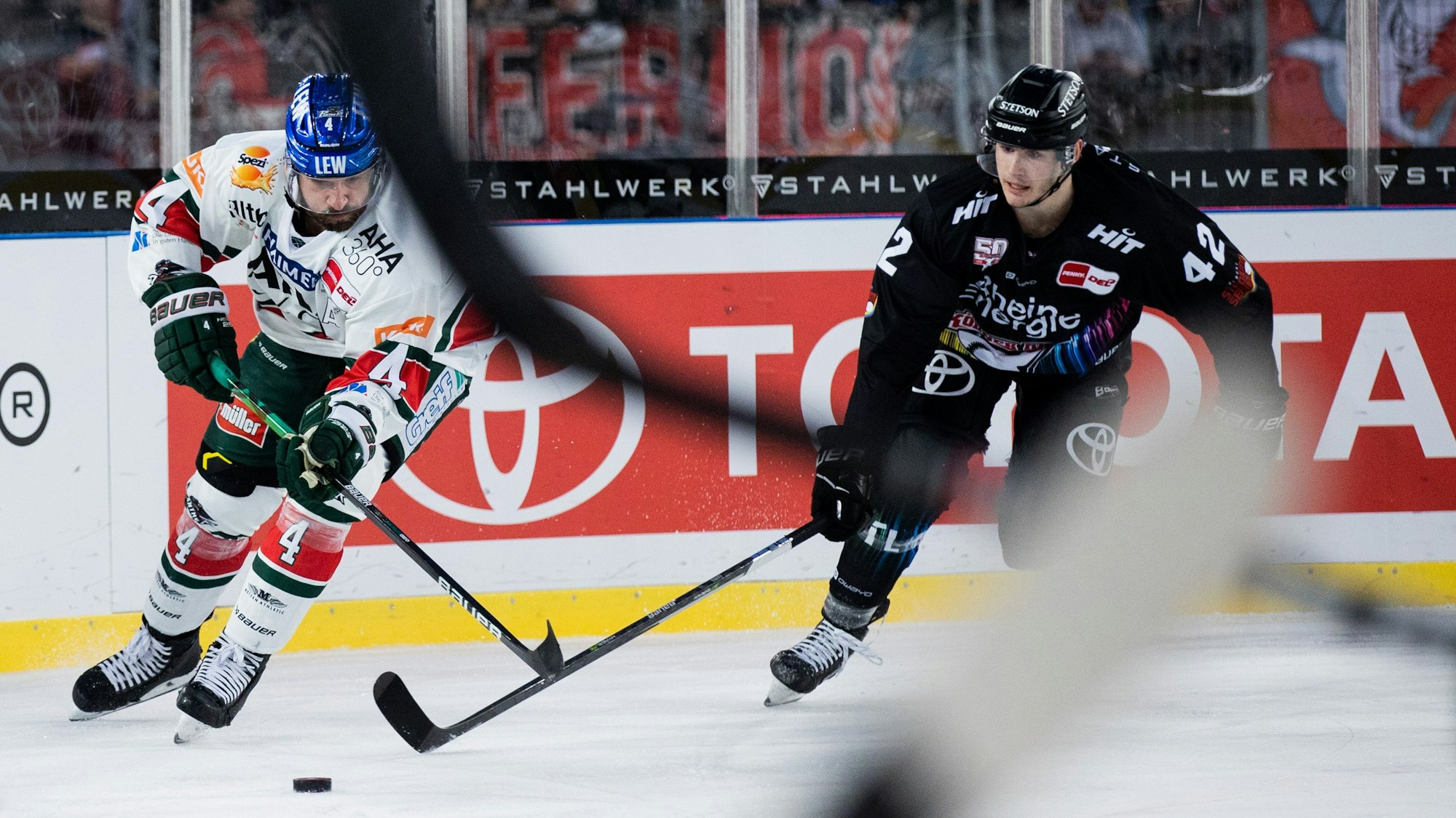 Kölns Luis Üffing (r) und Augsburgs Henry Haase versuchen, an den Puck zu kommen.