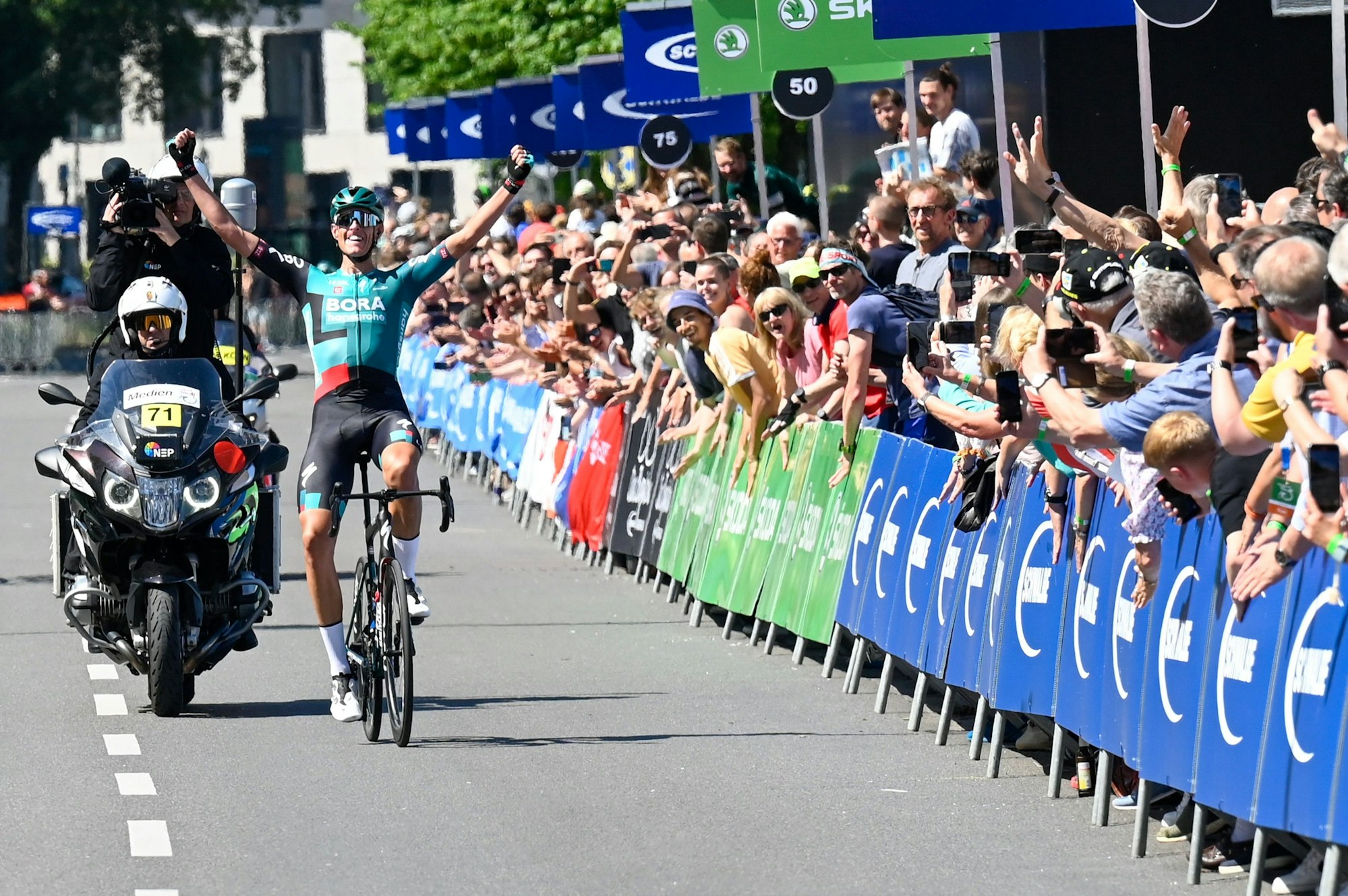 Nils Politt gewinnt das Radrennen „Rund um Köln“ und jubelt bei der Zieldurchfahrt.