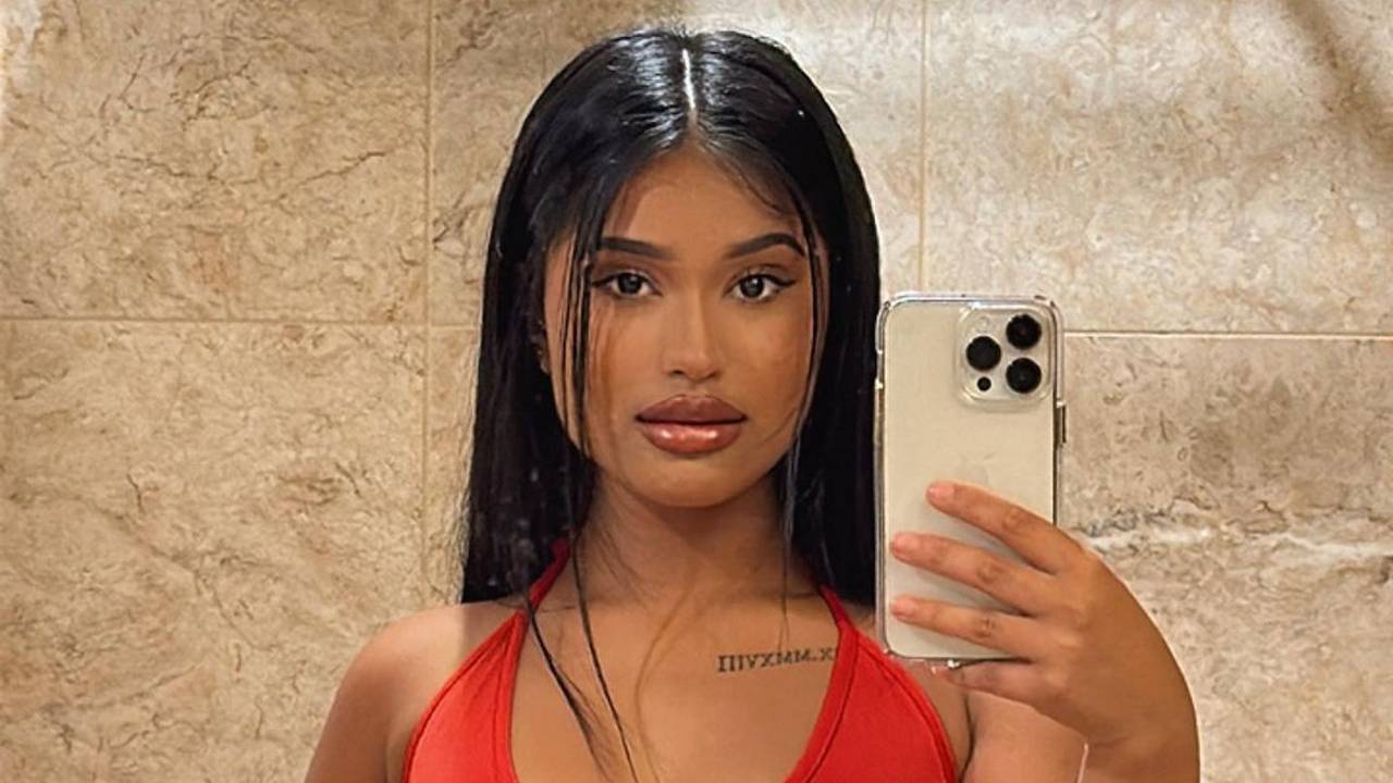 TikTokerin und OnlyFans-Model Tia Kabir in einem roten Kleid und einer roten Rose.