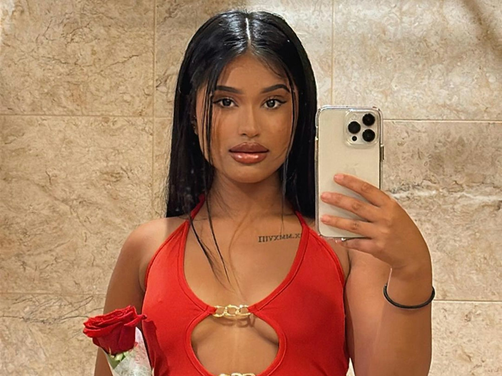 TikTokerin und OnlyFans-Model Tia Kabir in einem roten Kleid und einer roten Rose.