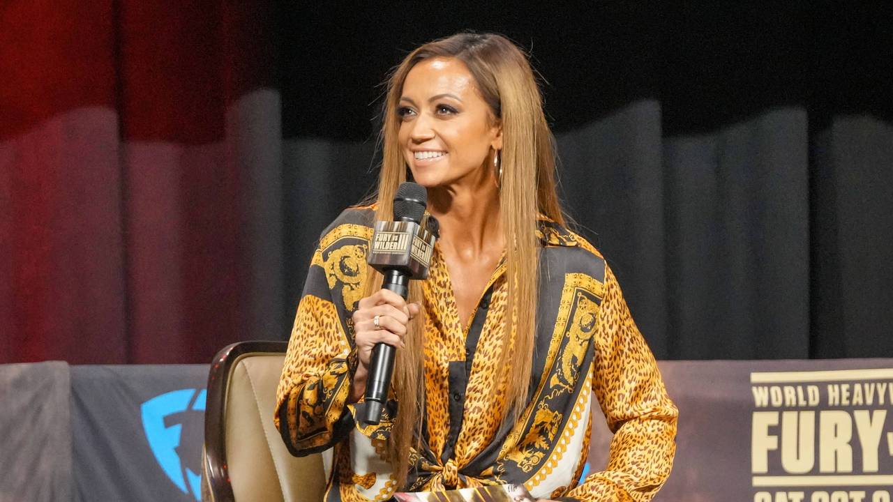 Kate Abdo sitzt auf einem Podium und moderiert.