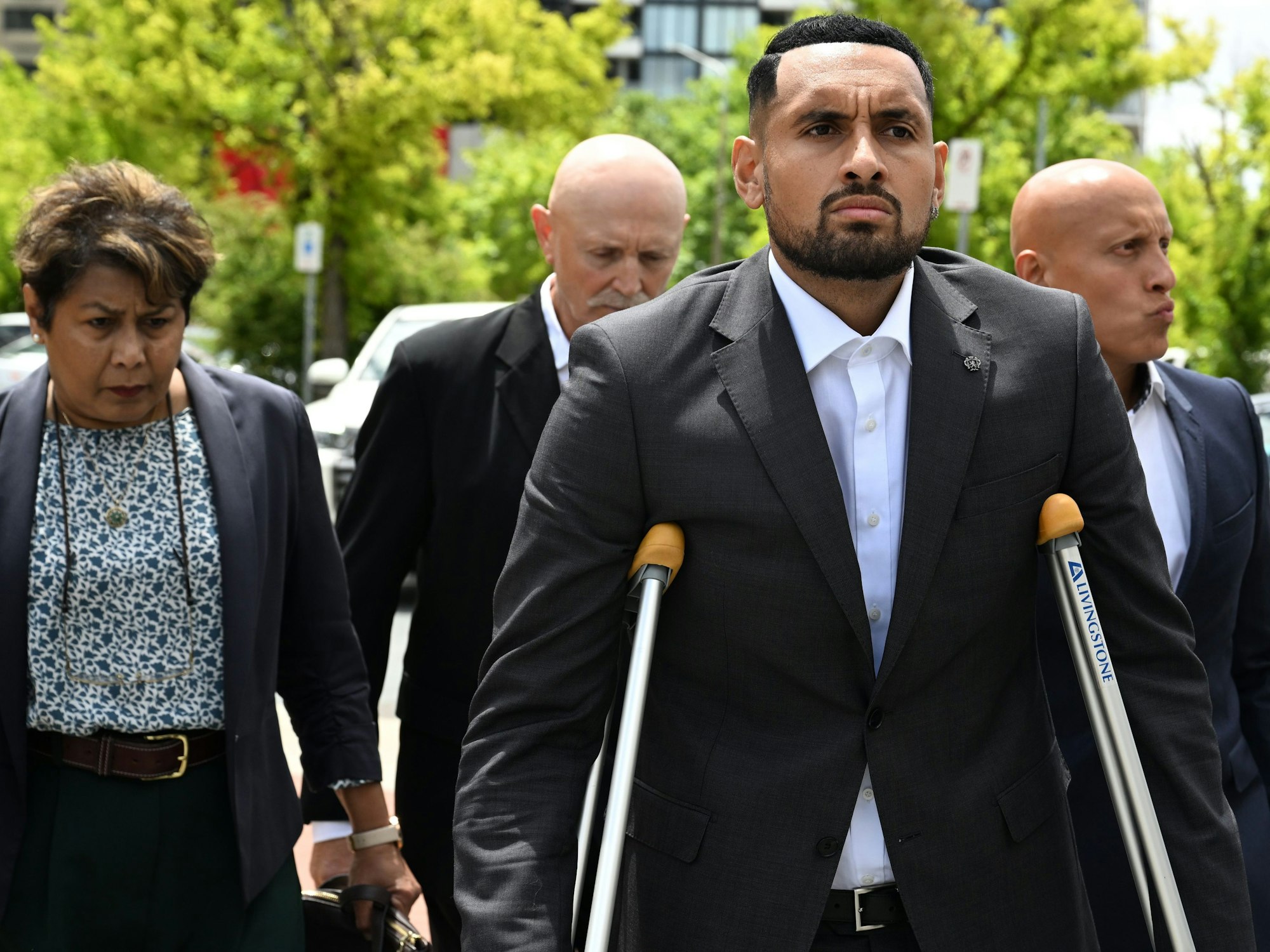 Tennisstar Nick Kyrgios kommt auf Krücken und in Begleitung seiner Familie am ACT Magistrates Court in Canberra an.