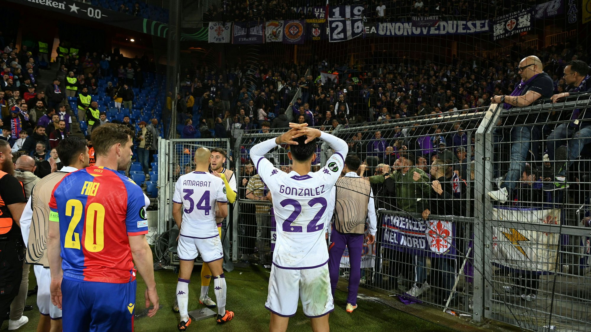 Spieler von Basel und Florenz gucken mit bangen Blicken Richtung Gästeblock.