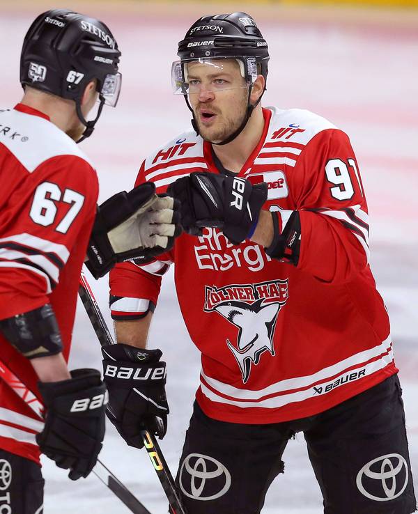 Stanislav Dietz (l.) und Moritz Müller von Kölner Haie klatschen sich ab.