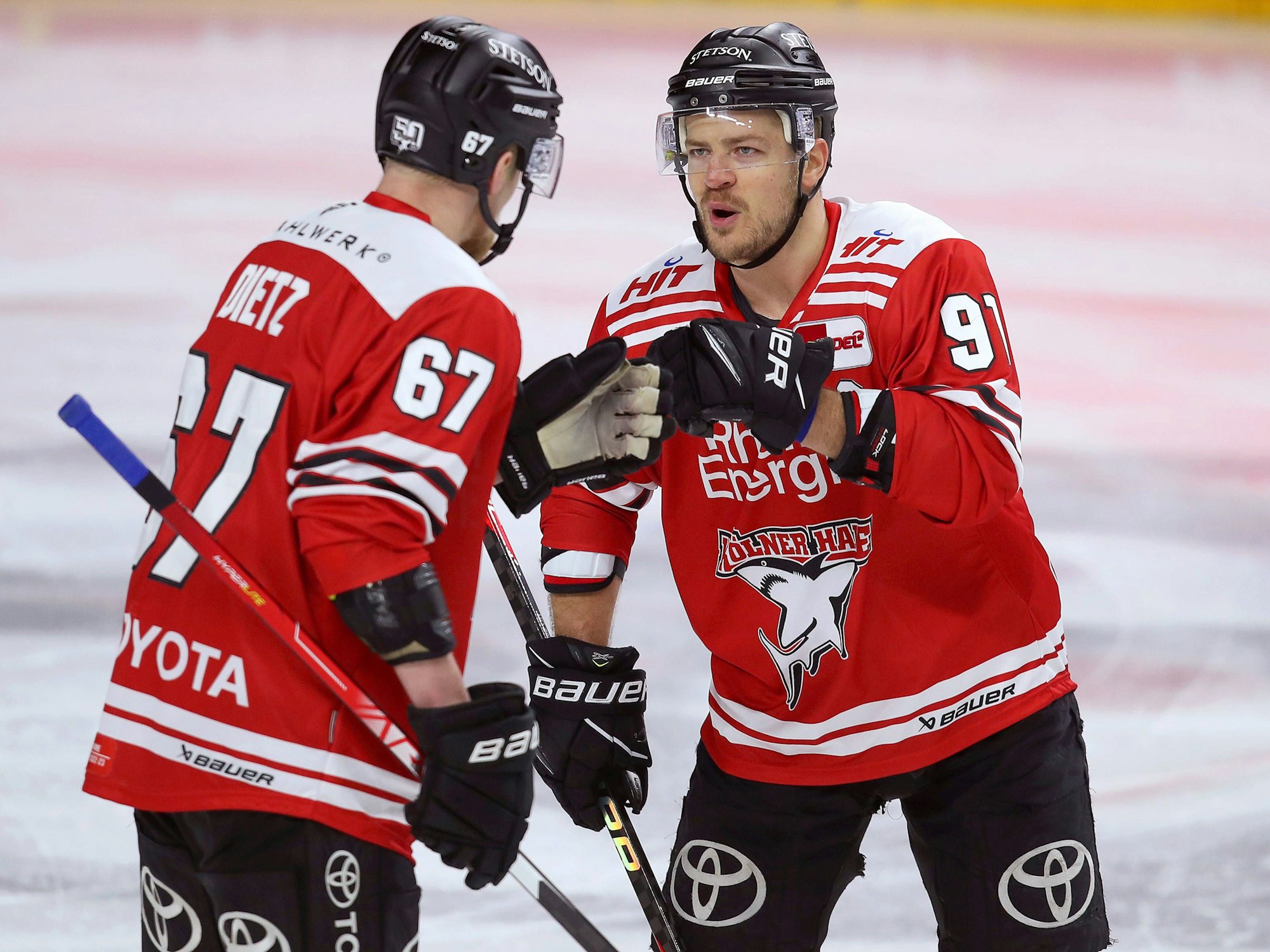 Stanislav Dietz (l.) und Moritz Müller von Kölner Haie klatschen sich ab.