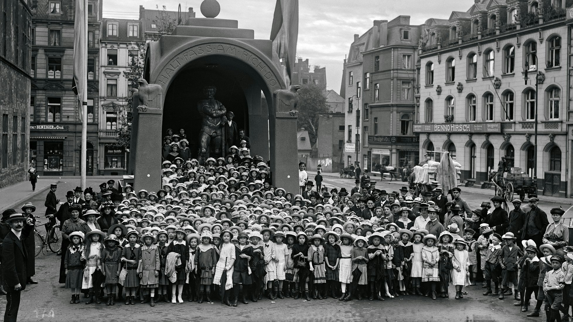 Hunderte Schülerinnen stehen 1915 vor der Figur des Kölschen Boor.