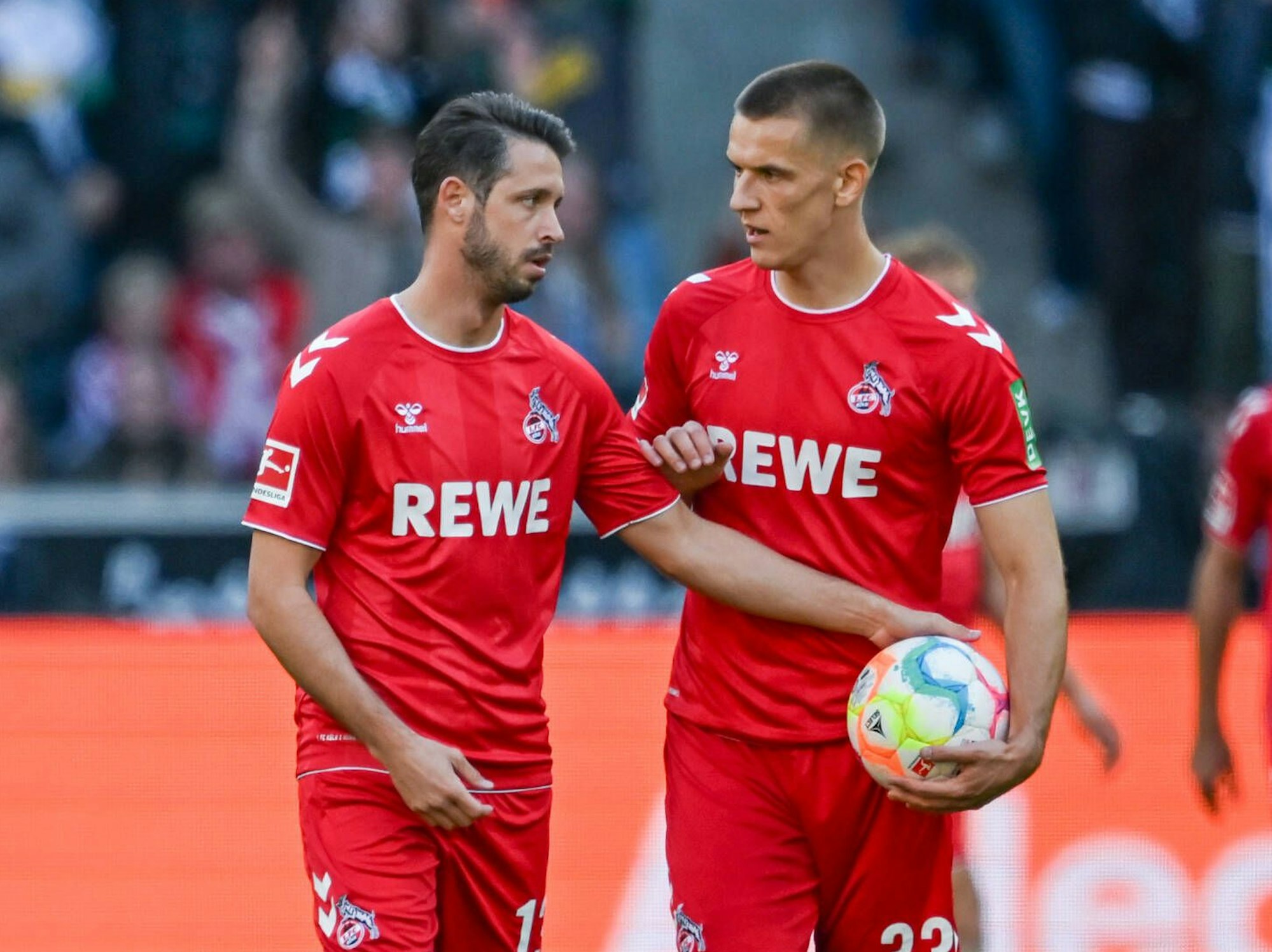 Mark Uth und Florian Dietz stehen gemeinsam auf dem Platz.
